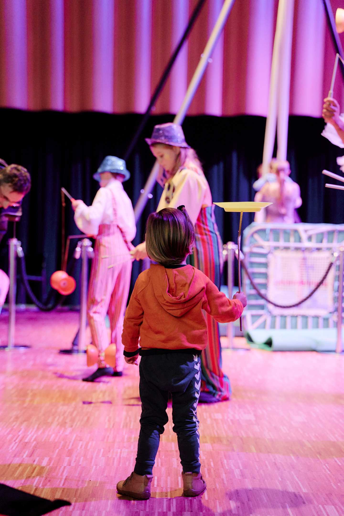 Children taking part in various circus activities inside the museum. Photograph.