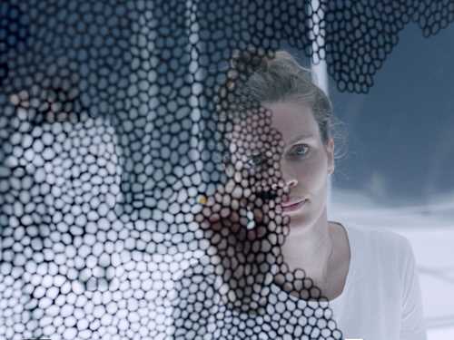 Photo of a woman drawing circles on the camera lence.