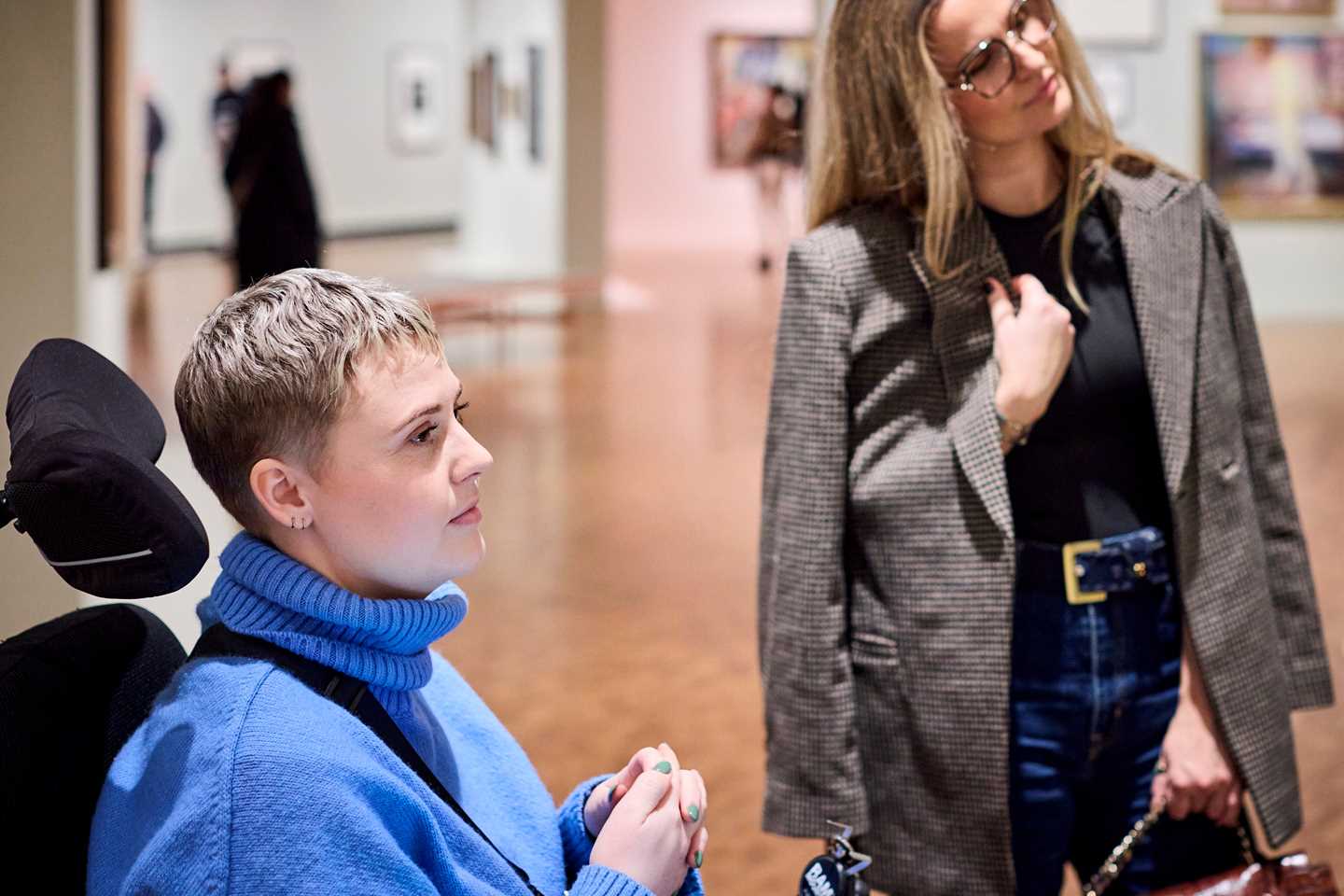 Two women looking at an artwork in the Infinite exhibition. Photograph.