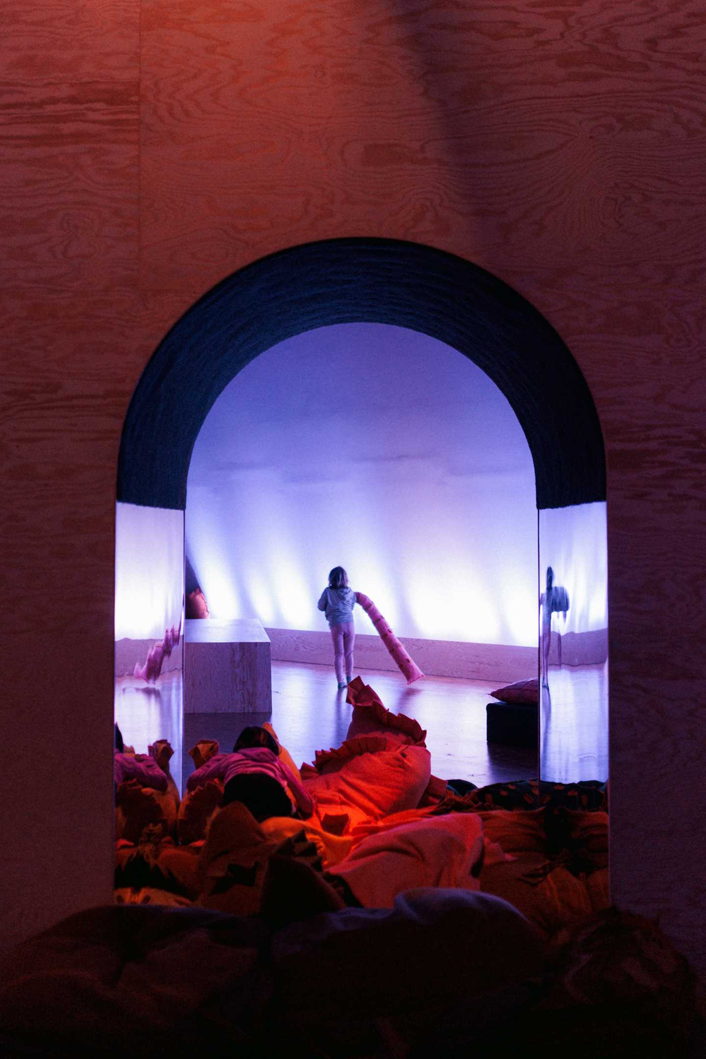 Kids playing in The Chamber of Chaos, a wonderful world of portals, colourful pillows and textile figures, surrounded by magical lighting