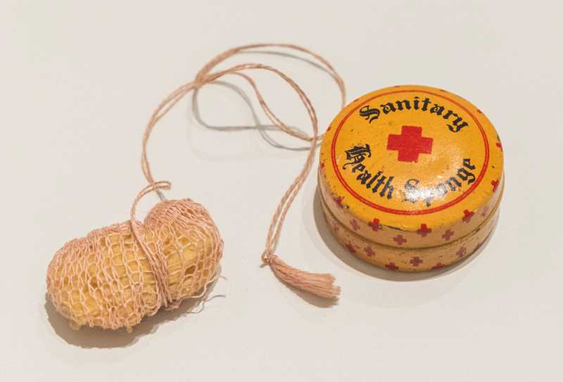An old sanitary sponge with a matching tin case. 