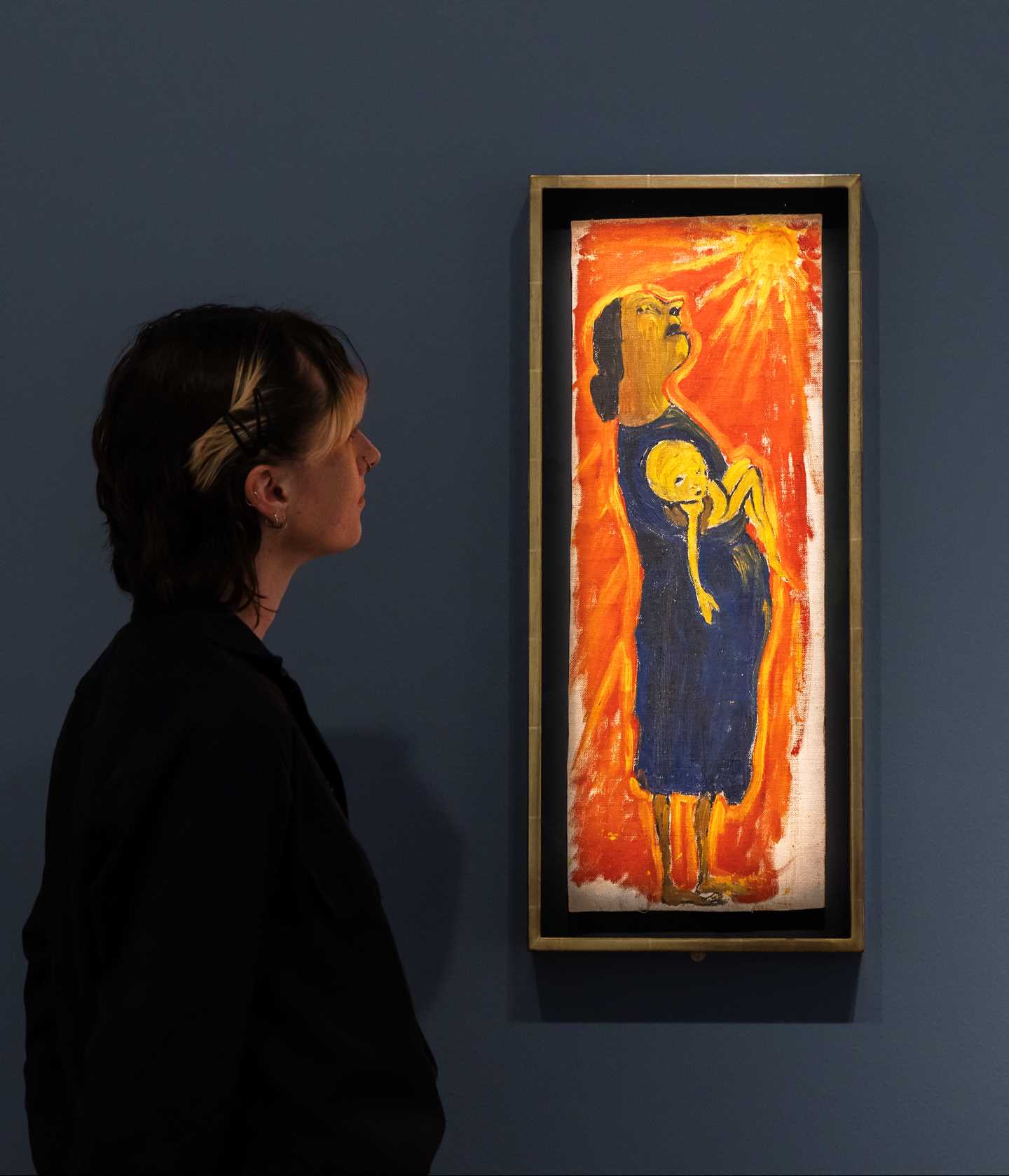 A woman looks at the work The Drought by Paula Rego. Photograph.