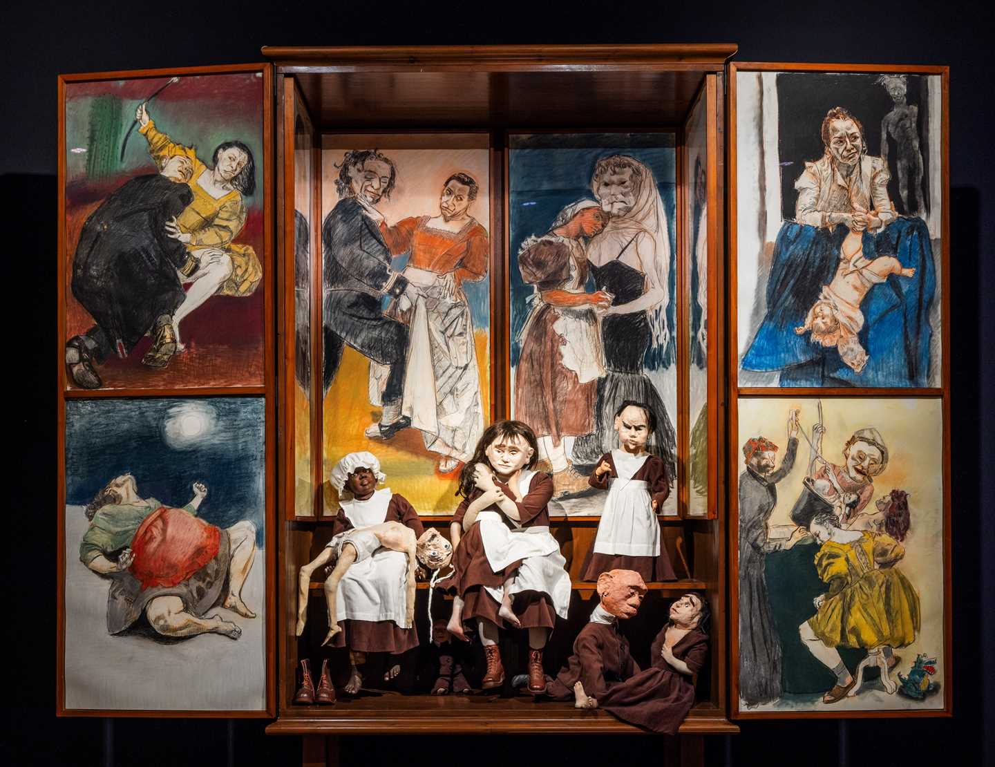 An altarpiece featuring six different pastels and seven textile dolls by Paula Rego. Photograph.