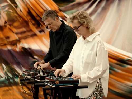 Photo of a man and a woman playing a synth concert in an exhibition space.