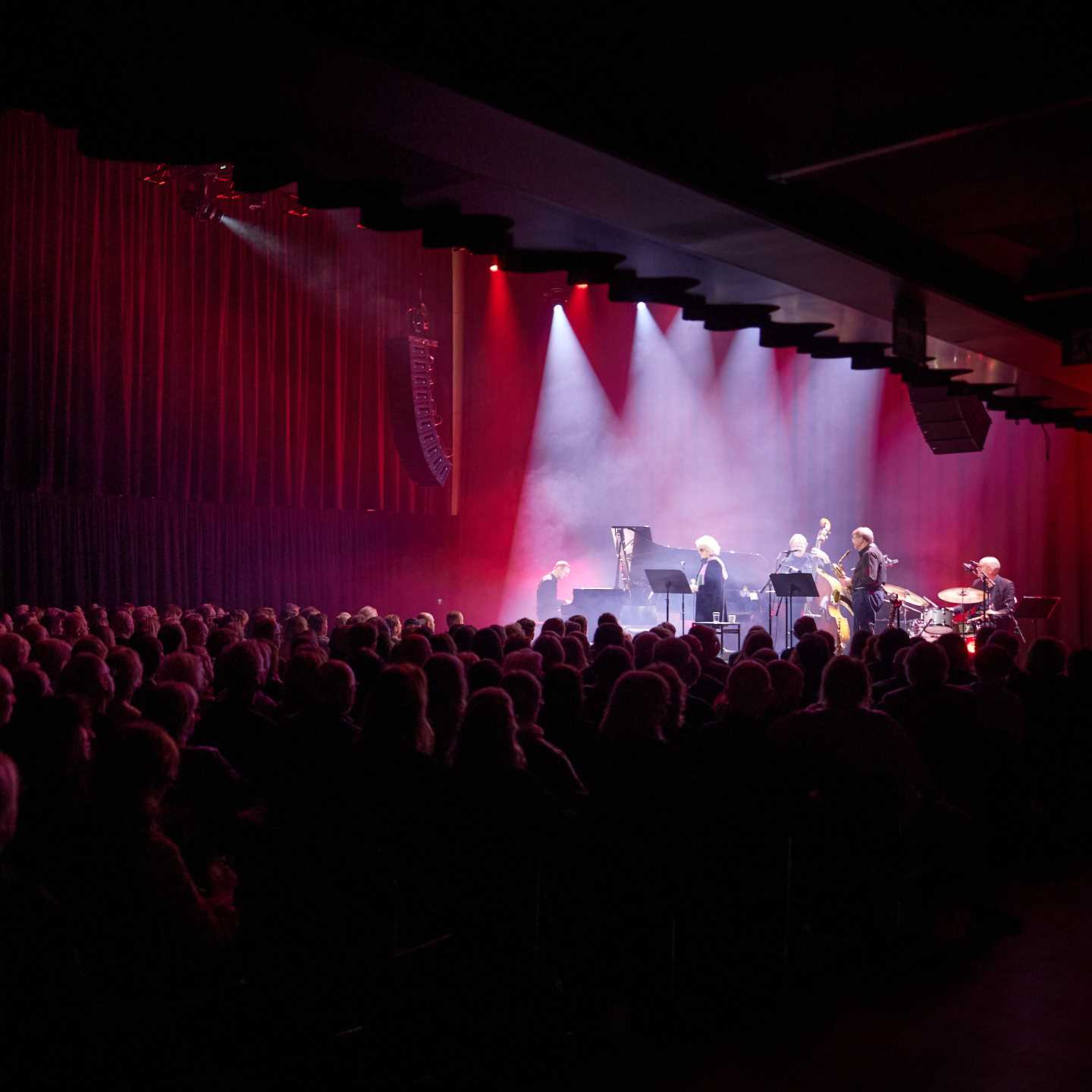 Jazz musicians on stage in a full concert hall