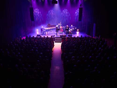 Jazz musicians on stage in a full concert hall